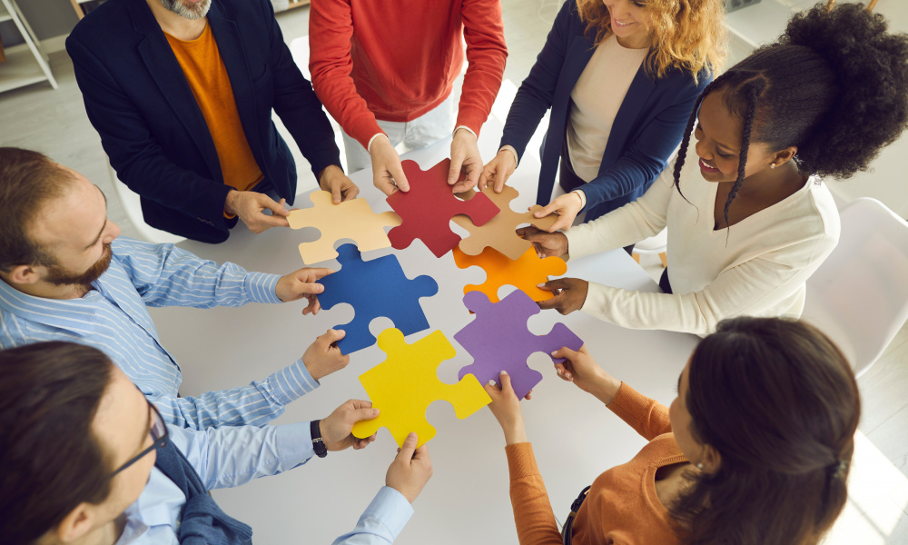 Business Team Joining Puzzle Parts As Metaphor For Teamwork And Finding Solution To Problem