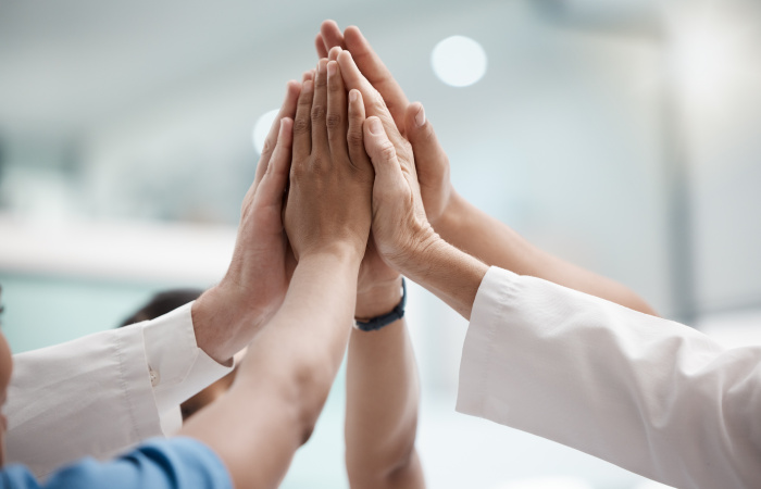 High Five, Teamwork And Doctors Hands In Collaboration For Mission, Goal Or Team Building Together. Mindset, Target Or Medical Group With Trust, Motivation Or Support For Vision, Winning Or Success.